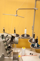 string of black and white threads on white sewing machine on yellow wall