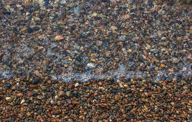 Pebble beach and the crystal clear water of lake Baikal