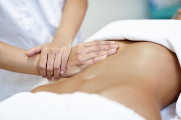 Fototapeta na wymiar Hands massaging female abdomen.Therapist applying pressure on belly.