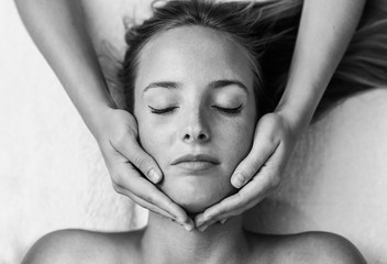 Young woman receiving a head massage in a spa center.