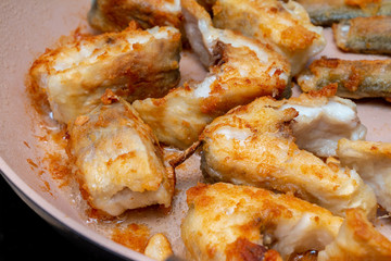 Pieces of fish fried in a hot pan