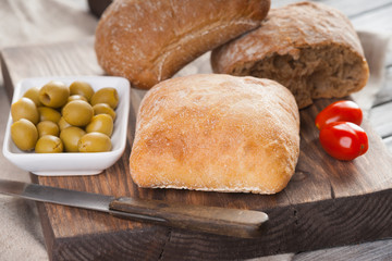 Homemade bread, tomatoes, olives and knife 