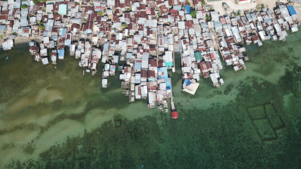 Aerial photo poor water village in Asia. Climate change threatens these coastal slums. Poverty © Richard Carey
