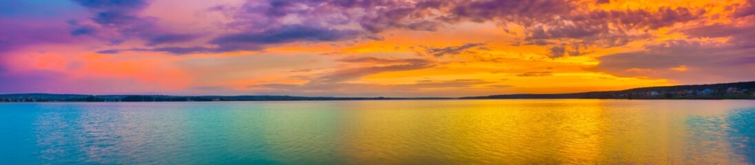 Naklejka premium Zachód słońca nad jeziorem. Niesamowity krajobraz panoramiczny