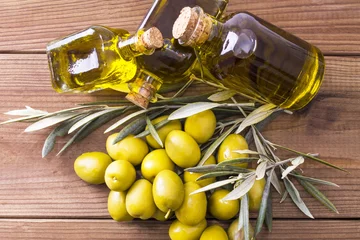 Fotobehang olives and bottles of extra virgin olive oil on wooden background © tetxu