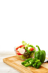 Full bowl of fresh salad on a white wooden