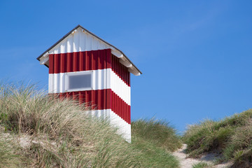 red and white beach cabin on danish seaside