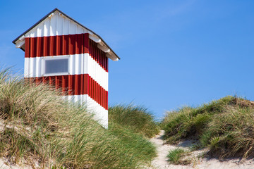 red and white beach cabin on danish seaside