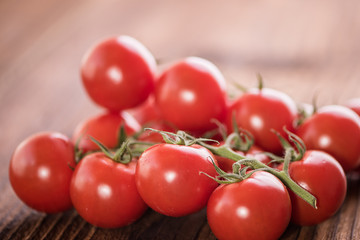 red ripe vine tomatoes on the vine on vintage old wooden background