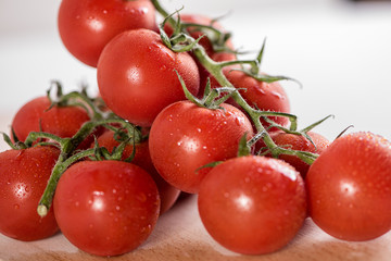 red ripe tomatoes in white bowl on white background with water drops condentation moisture 