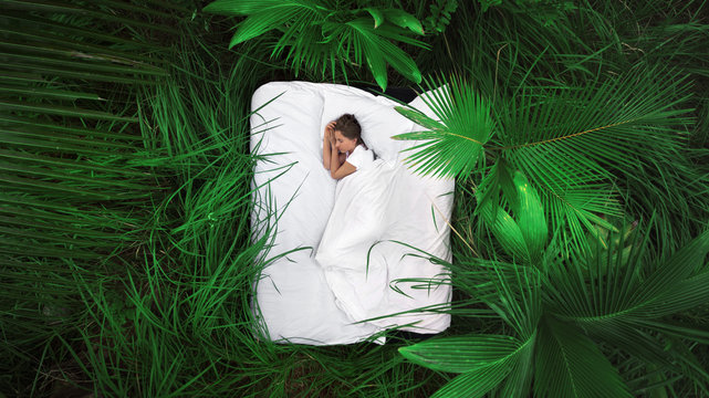 A hidden place. Sleeping woman in deep jungle forest lies on airbed,View from above