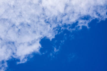 Fototapeta na wymiar White clouds occupy half of the blue sky