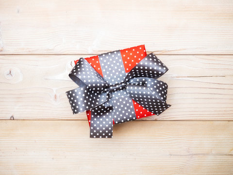 Red gift box on wooden board. Copy space. Holidays concept