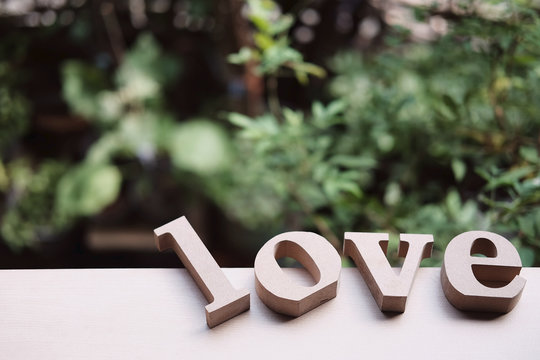 Wooden letters word "LOVE" on wood floor.Love text in nature garden.Use for Valentine day and vintage style concept background.Wooden alphabets & Words.Copy space