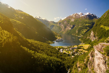 Geiranger village and ferry surrounded by mountains in sunny weather, Sunnmore, Romsdal, Norway