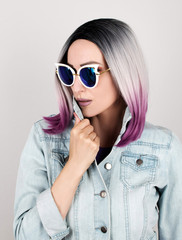 Young woman wearing sunglasses and denim jacket