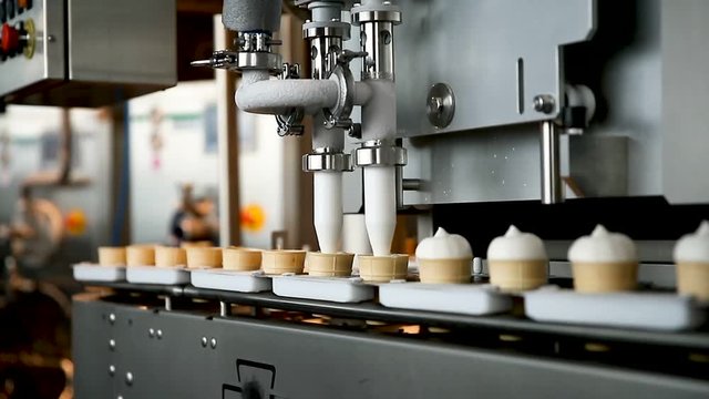 Filling of wafer cups with ice cream. Ice cream production line. Vanilla ice cream. Ice cream production line.