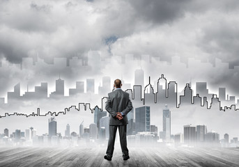 Motivation and inspiration concept with modern cityscape and businessman observing it