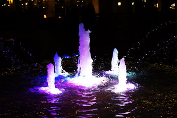 fountain lit up at night in the summer