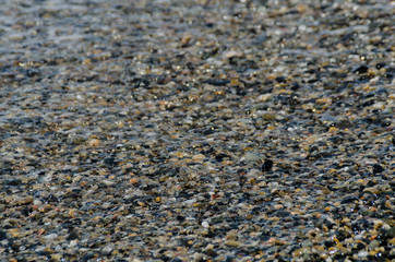 pebble beach washed by sea waves, small and various stones forming the shore