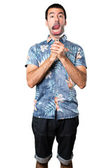 Handsome man with flower shirt with magnifying glass on isolated white background