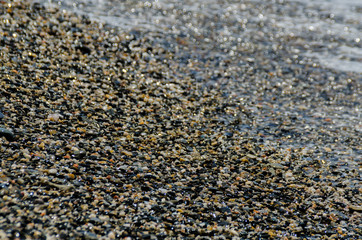 pebble beach washed by sea waves, small and various stones forming the shore