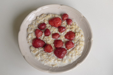 Oatmeal porridge on milk with strawberries. Perfect as a healthy breakfast.