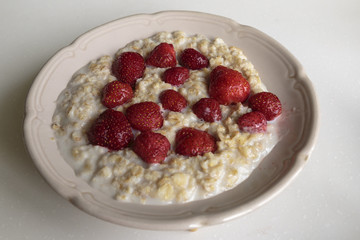 Oatmeal porridge on milk with strawberries. Perfect as a healthy breakfast.