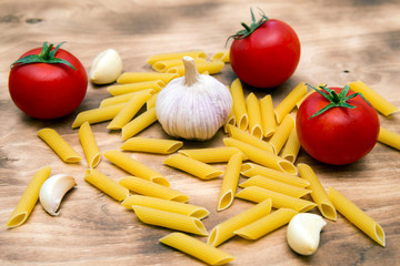 pasta, fresh tomatoes and garlic on a wooden table close-up