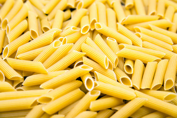 Close-up of raw penne pasta, texture or background, italian design.