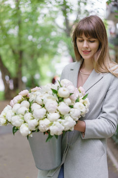 Beautiful bouquet of white peonies in woomans hands . Floral composition, daylight. Wallpaper. Vertical photo