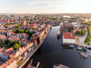Fototapety  Zdjęcie starego miasta Gdańska architektura w świetle zachodu słońca. Zdjęcia lotnicze. Kanał i budynki - widok z góry