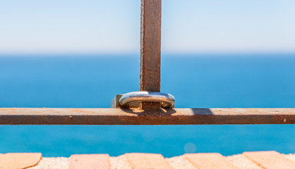 rusty padlock attached to a balustrade by the sea, a traditional way of showing love