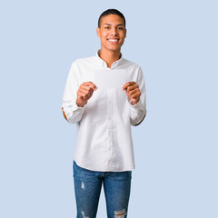 Young african american man with white shirt holding an empty white placard for insert a concept on...