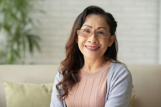 Portrait of Asian smiling mature woman sitting at home