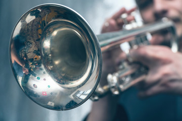 The trumpeter is playing on a silver trumpet. Trumpet player - obrazy, fototapety, plakaty