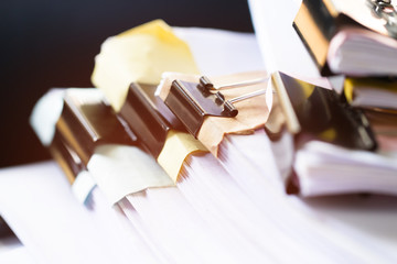 Unfinished documents stacks of paper files on office desk for report papers, piles of unfinish sheet achieves with black clips. Document is written presented. Business offices busy concept.