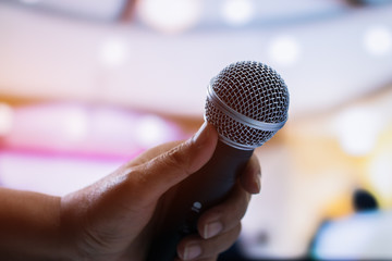 Seminar Conference Concept : hands businesspeople holding microphones for speech or speaking  in seminar room, talking for lecture to audience university, Event light convention hall Background.