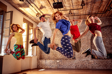 Dance team - happy dance friends jumping during music © luckybusiness
