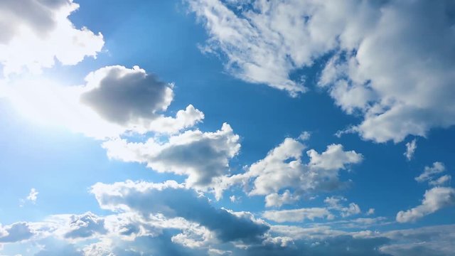 moving clouds on the blue sky lit with sunlight