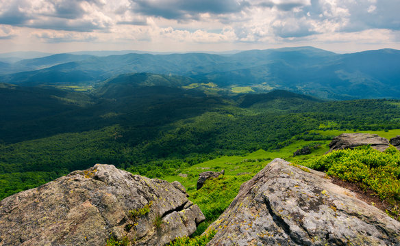 rocks on the edge of a  mountain. location Pikui mountain. Runa mountain in the far distance. Beautiful summer landscape of Carpathian mountains on a cloudy day