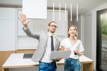 Young woman planning interior with designer standing together with digital tablet at the new kitchen