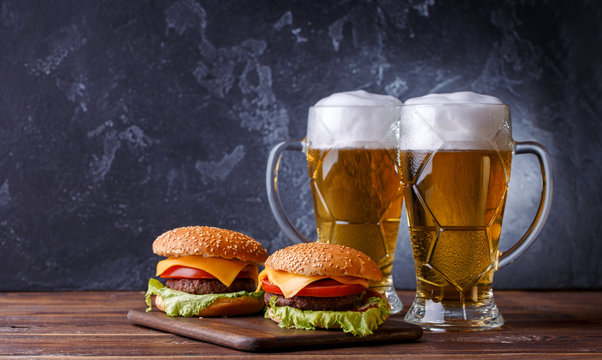 Photo of two hamburgers, glasses with beer