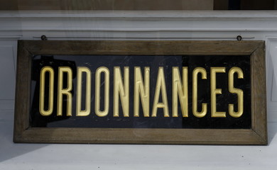 Obraz premium Ordonnances. Panneau de verre, lettres dorées sur fond noir