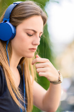 Sweetl girl listening music in big blue headphones