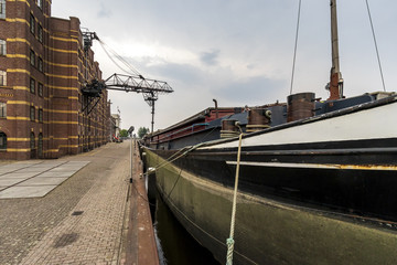 Barco de transporte de mercancía cargando en una fábrica junto al canal