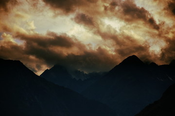 Forbidding pointy mountains under dramatic sunset clouds