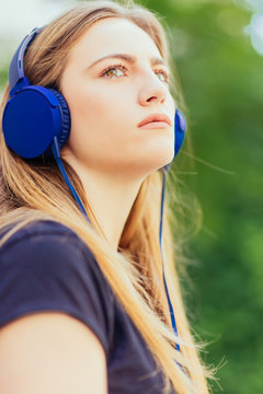 CLOSEUP PORTRAIT OF YOUNG GIRL LISTENING TO MUSIC