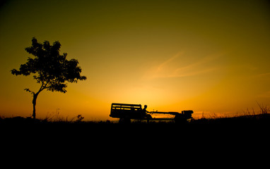 Fototapeta premium Silhouette Farmer driving a tractor in the field. 