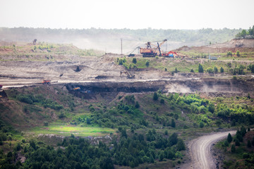 Dump trucks and excavators working at open coal mine